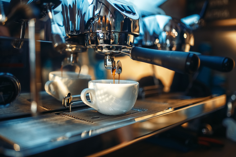 Espressomaschine mit eingespanntem Siebträger, aus dem Kaffee in eine weiße Espressotasse läuft