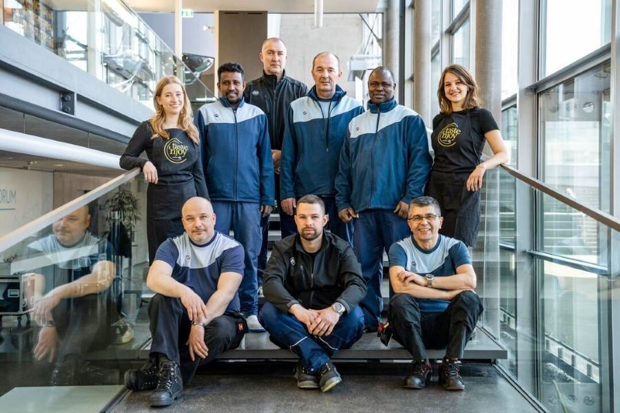 Team von ISS Österreich auf einer Treppe in einem modernen Bürogebäude