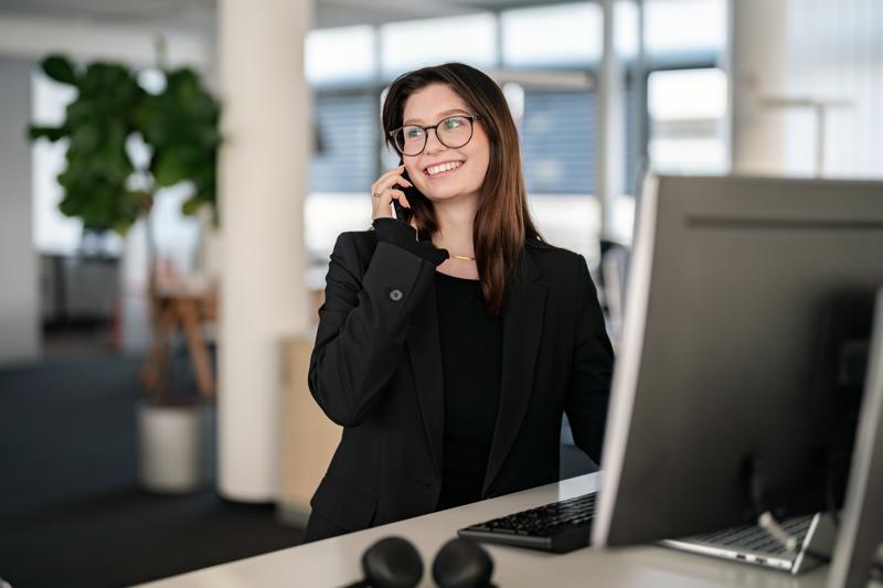 Arbeitsplatz im Büro mit Person bei organisatorischen Tätigkeiten und Dokumentenbearbeitung.