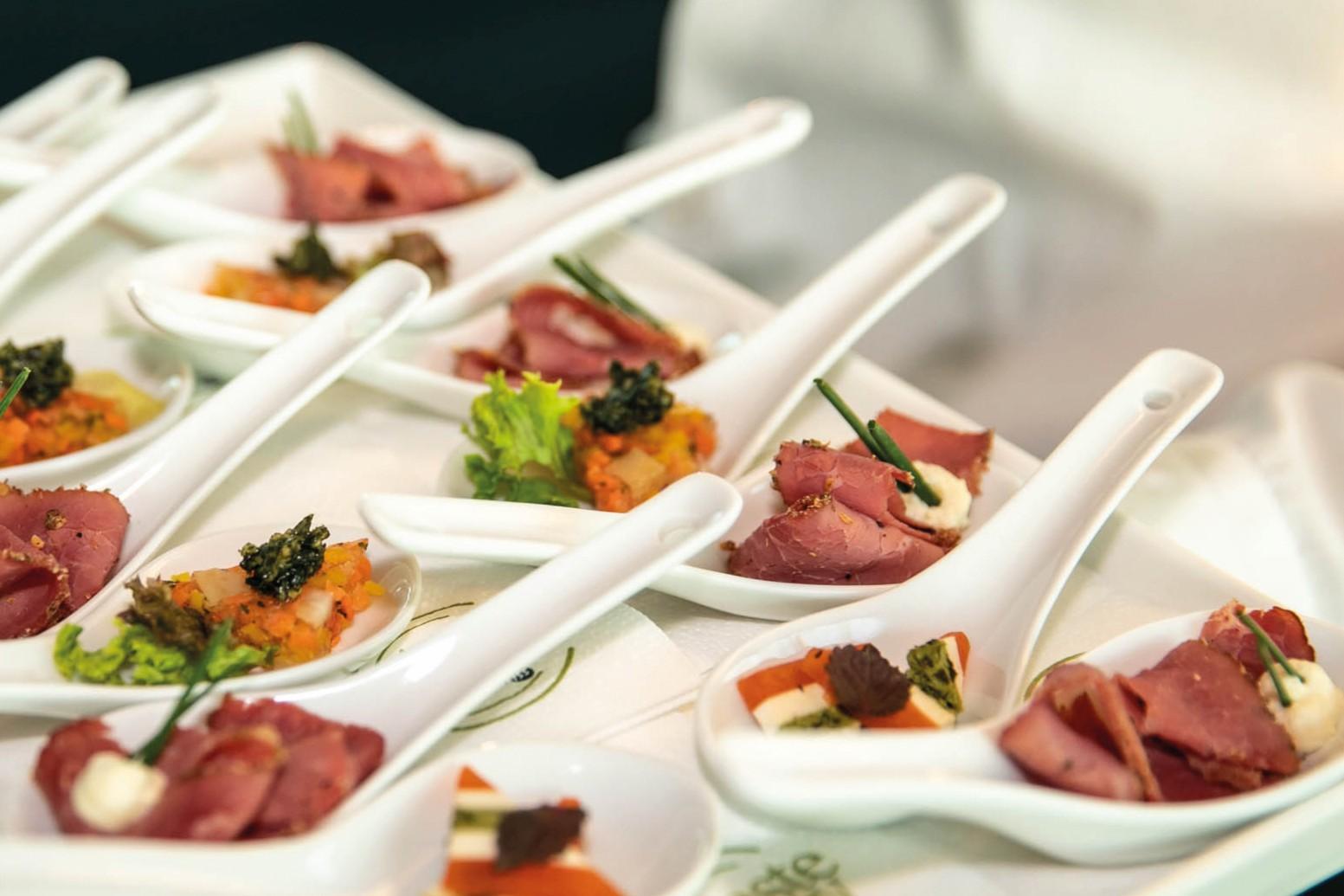 Canapés und Fingerfood von taste'njoy Premium Catering auf einer Servierplatte bei einer exklusiven Veranstaltung.