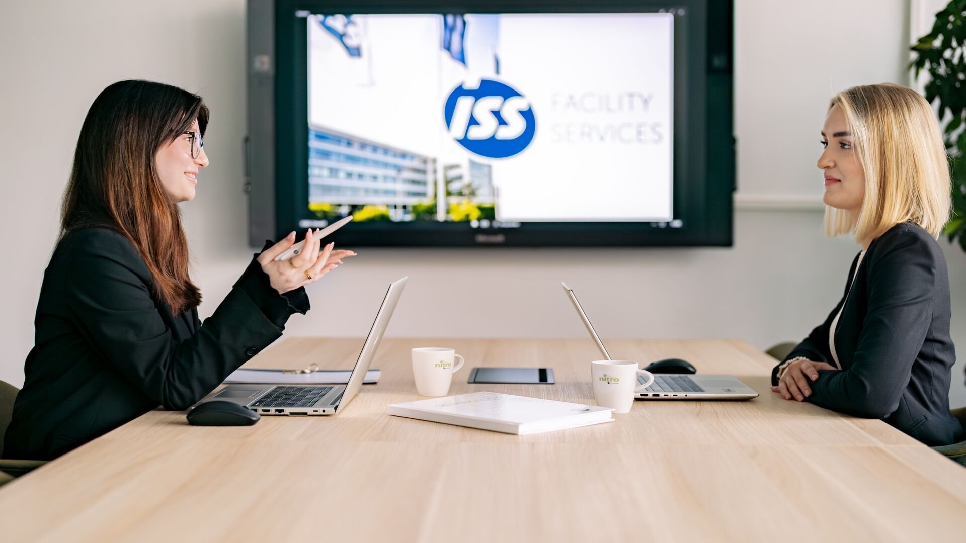 Mehrere Mitarbeitende im Austausch in einem Arbeitsumfeld im Kontext Ausbildung und Karriere.