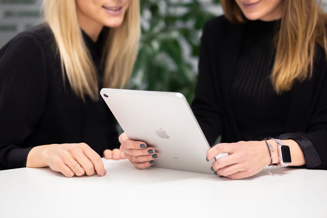 Zwei Mitarbeitende nutzen gemeinsam ein Tablet.